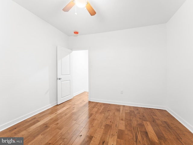 empty room featuring light wood-style floors, ceiling fan, and baseboards