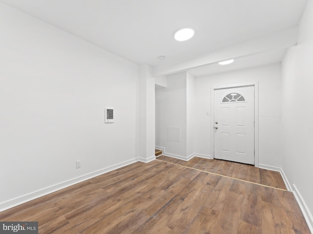 foyer entrance featuring baseboards and wood finished floors