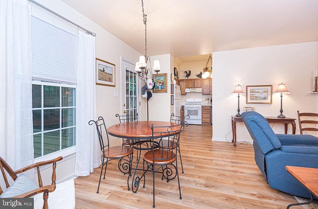 dining room with light wood-type flooring and a chandelier