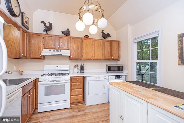 kitchen featuring lofted ceiling, decorative light fixtures, white appliances, wood counters, and washer / dryer