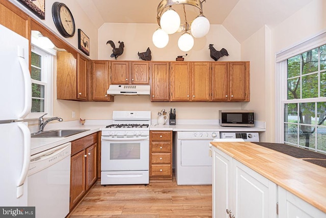 kitchen featuring butcher block countertops, sink, white appliances, vaulted ceiling, and pendant lighting