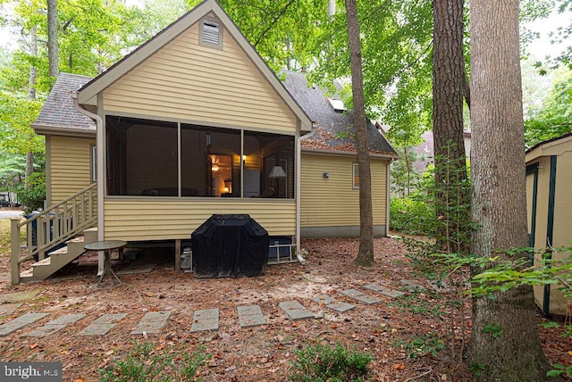 rear view of property featuring a sunroom