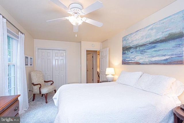 carpeted bedroom with ceiling fan and a closet