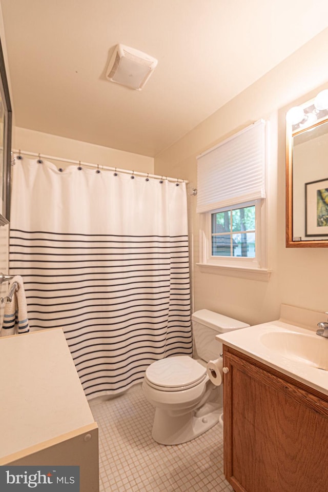 bathroom featuring curtained shower, vanity, toilet, and tile patterned floors