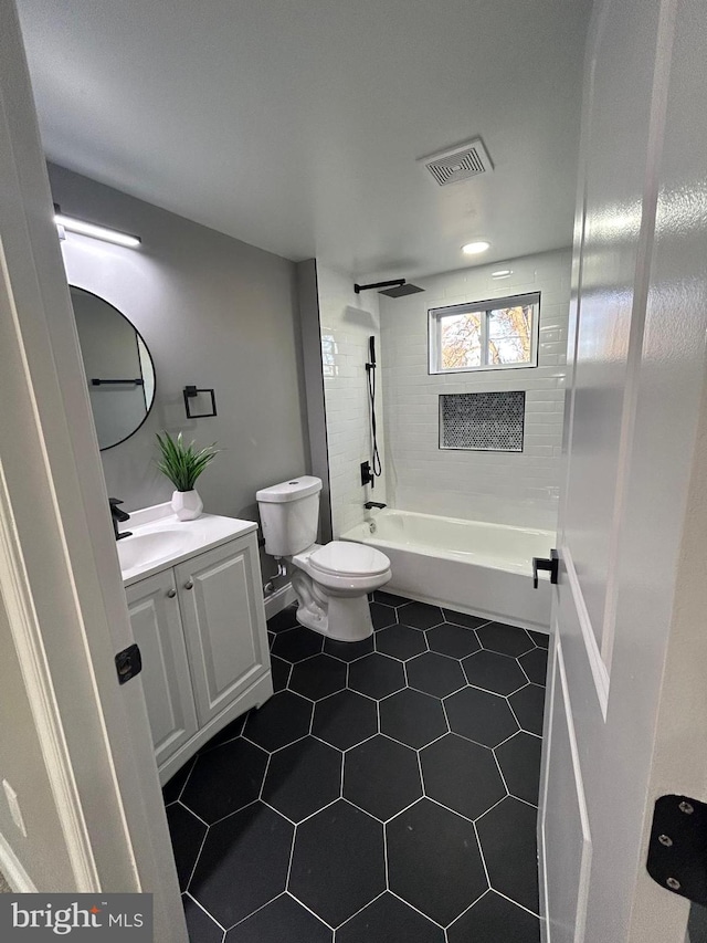 full bathroom with tiled shower / bath combo, vanity, toilet, and tile patterned floors