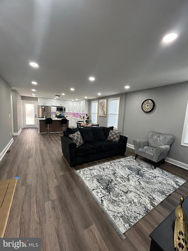 living room featuring a wealth of natural light and dark hardwood / wood-style flooring