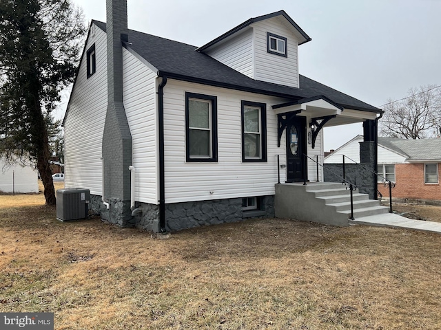 view of front facade with a front lawn and cooling unit