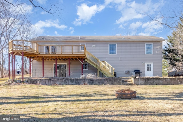 back of house featuring a yard, a deck, and an outdoor fire pit