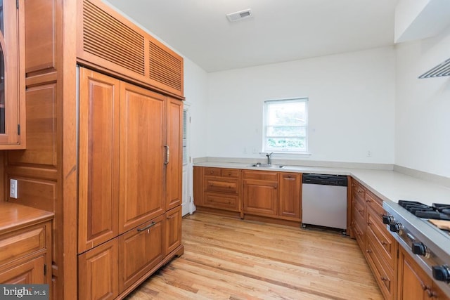 kitchen with light wood-type flooring, stainless steel appliances, and sink