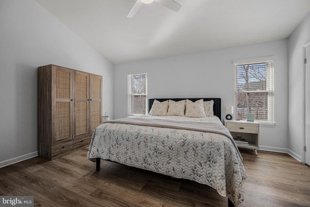 bedroom with vaulted ceiling, multiple windows, and wood finished floors