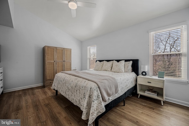 bedroom featuring lofted ceiling, wood finished floors, and baseboards