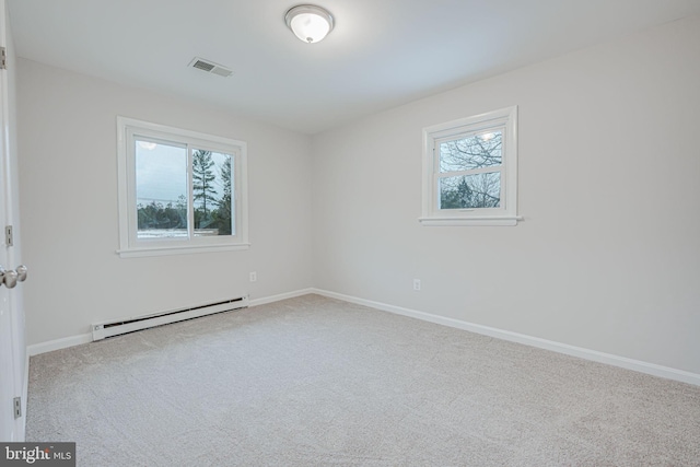 empty room with a baseboard heating unit and light colored carpet