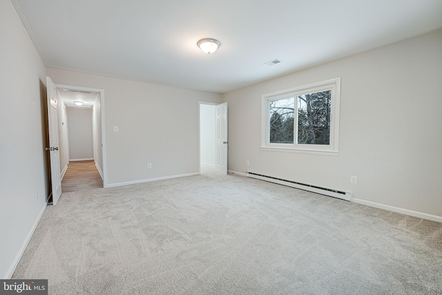 unfurnished bedroom featuring light colored carpet and baseboard heating