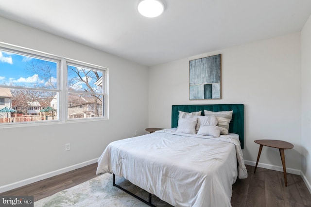 bedroom with baseboards and wood finished floors