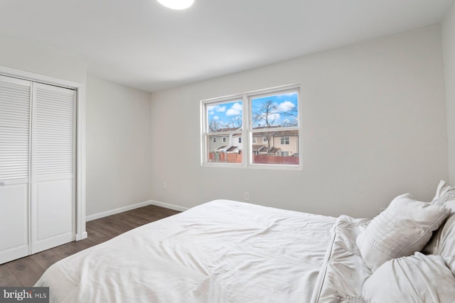 bedroom featuring a closet, wood finished floors, and baseboards