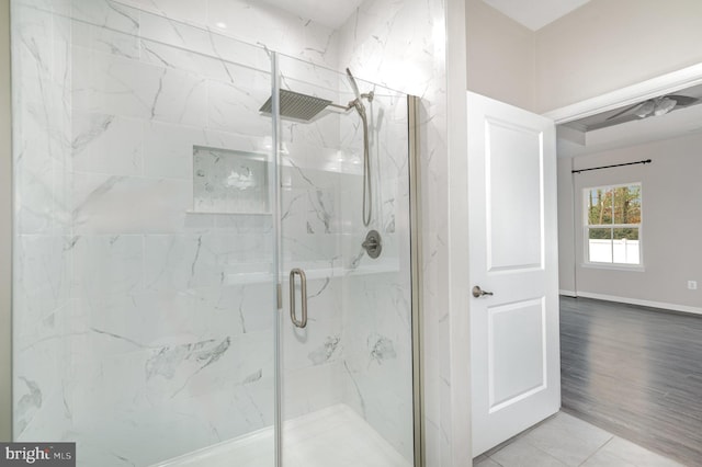 full bath with a marble finish shower and baseboards