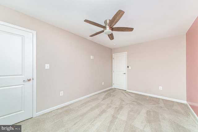 unfurnished room with ceiling fan, baseboards, and light colored carpet