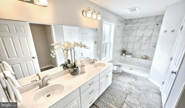 bathroom featuring a tile shower and vanity