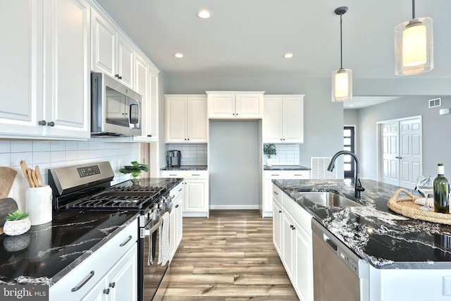 kitchen featuring sink, hanging light fixtures, white cabinetry, and stainless steel appliances