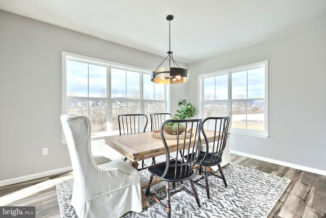 dining area with an inviting chandelier and hardwood / wood-style flooring