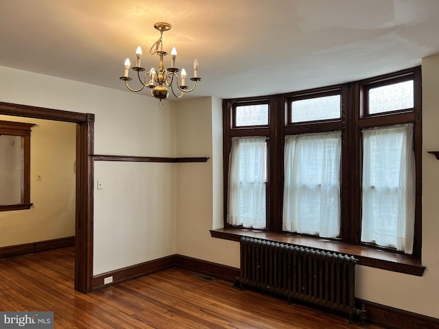 unfurnished dining area with radiator, plenty of natural light, baseboards, and wood finished floors