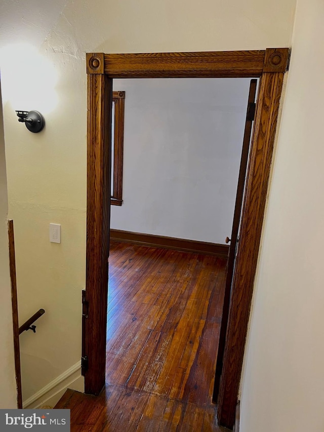 hallway with wood-type flooring and baseboards