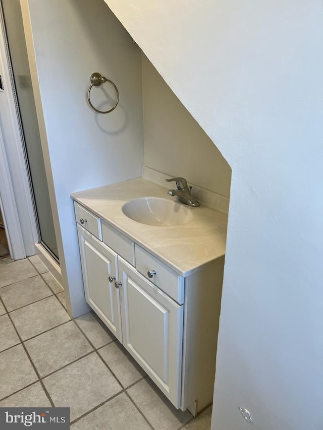 bathroom with a stall shower, vanity, and tile patterned floors