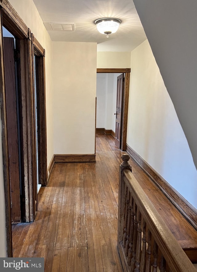 corridor with baseboards and hardwood / wood-style floors