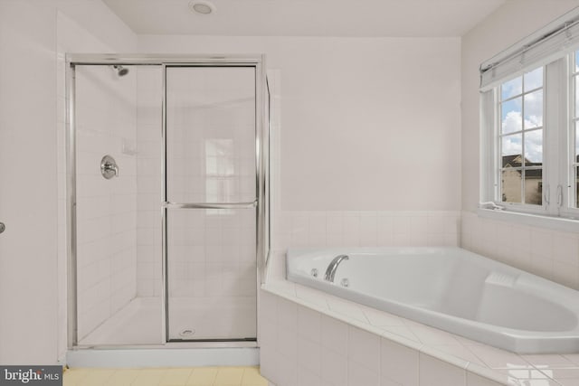 bathroom featuring shower with separate bathtub