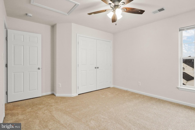 unfurnished bedroom with a closet, ceiling fan, and light colored carpet