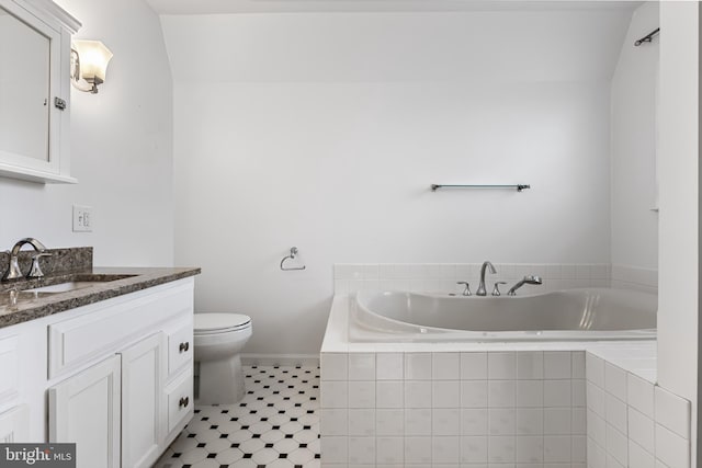 full bathroom featuring a bath, vanity, and toilet