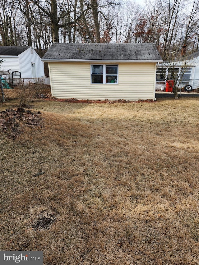 view of side of home with fence and a lawn