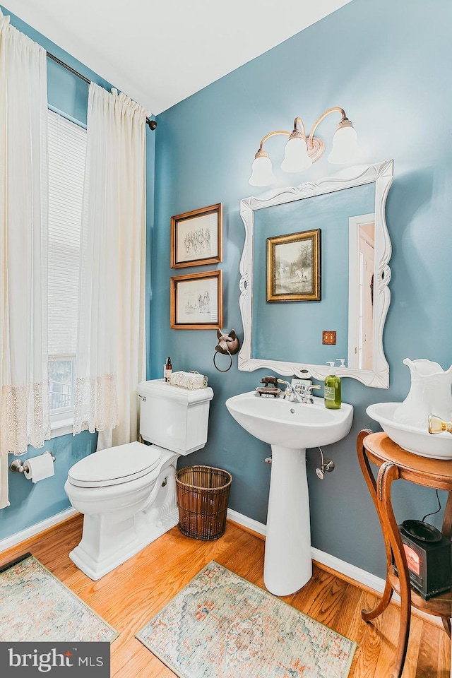 bathroom with hardwood / wood-style flooring and toilet