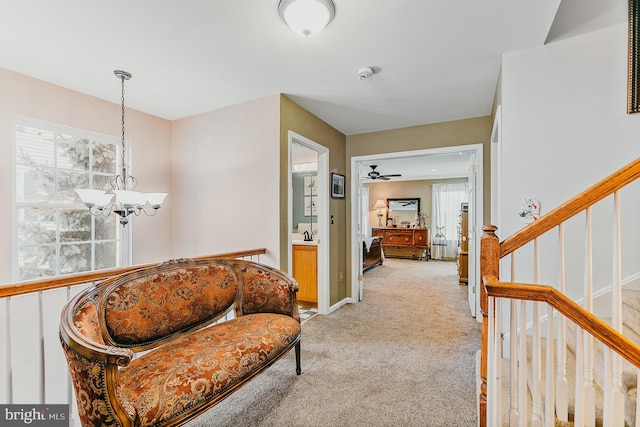 corridor featuring a chandelier and light colored carpet