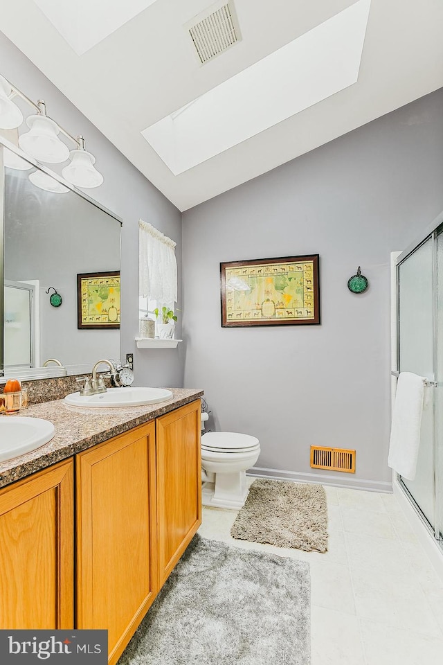 bathroom with vaulted ceiling with skylight, vanity, tile patterned floors, and walk in shower