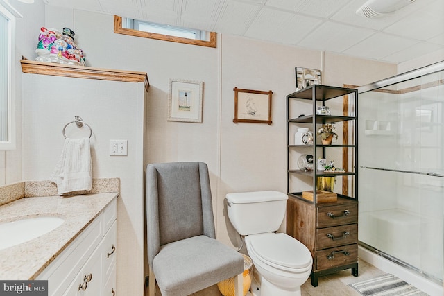 bathroom featuring toilet, vanity, and an enclosed shower