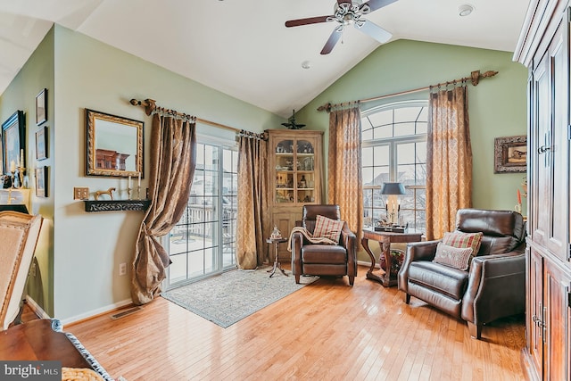 sitting room with light wood-type flooring, vaulted ceiling, and ceiling fan