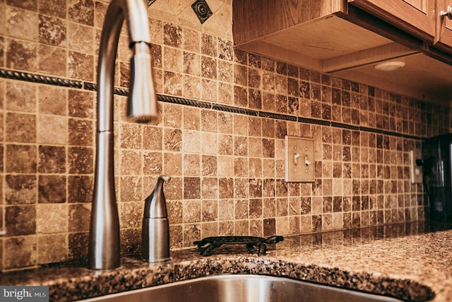 interior details with sink, stone counters, and decorative backsplash