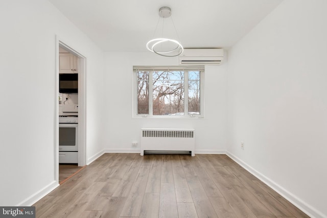 unfurnished dining area featuring baseboards, a wall unit AC, light wood-style flooring, and radiator