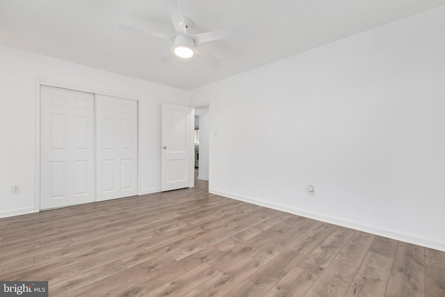 unfurnished bedroom featuring light wood-type flooring, a closet, and baseboards