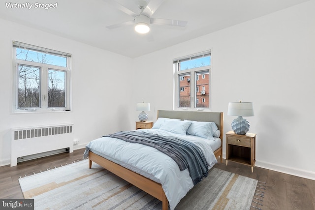 bedroom featuring radiator heating unit, wood finished floors, and baseboards