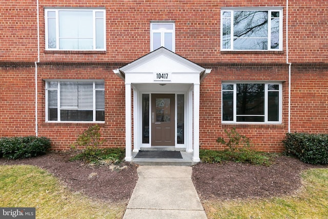 property entrance featuring brick siding