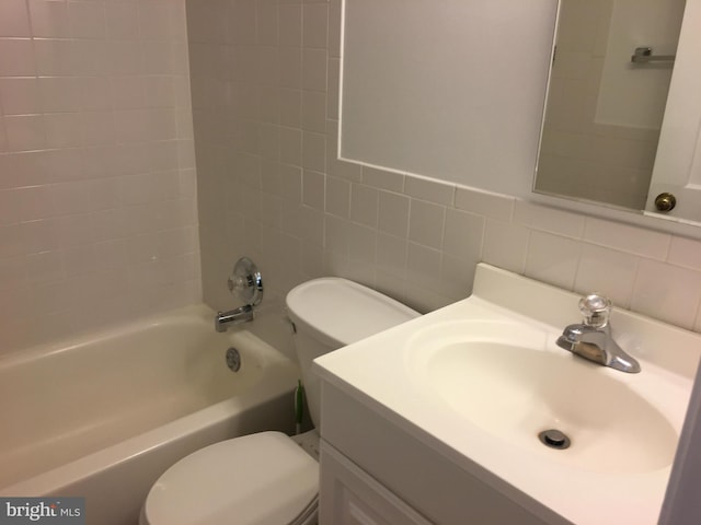 full bathroom with toilet, tile walls, tiled shower / bath, tasteful backsplash, and vanity