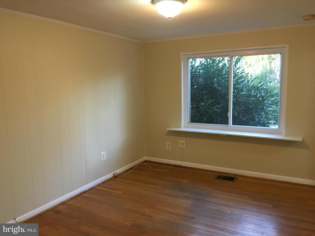 spare room with ornamental molding and hardwood / wood-style flooring