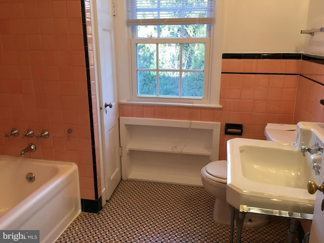 full bathroom featuring tile walls, shower / bathing tub combination, sink, and toilet