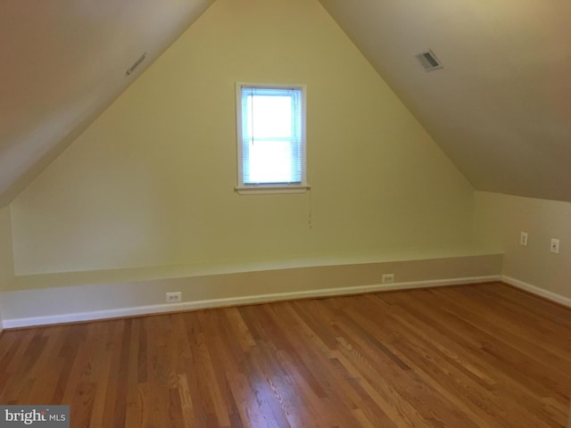 additional living space featuring vaulted ceiling and light hardwood / wood-style floors