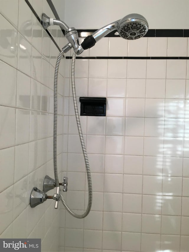 interior details featuring tiled shower