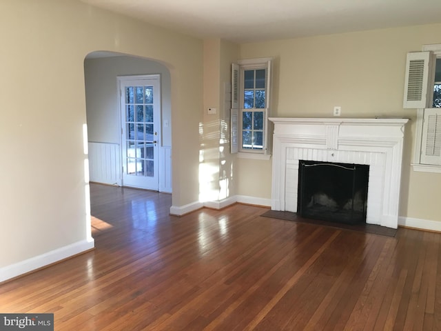 unfurnished living room with a fireplace and dark wood-type flooring