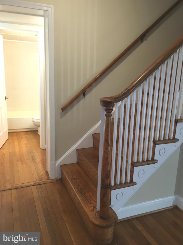 stairs featuring hardwood / wood-style flooring