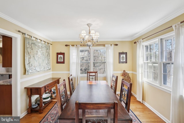 dining area featuring light wood-style floors, a notable chandelier, plenty of natural light, and baseboards